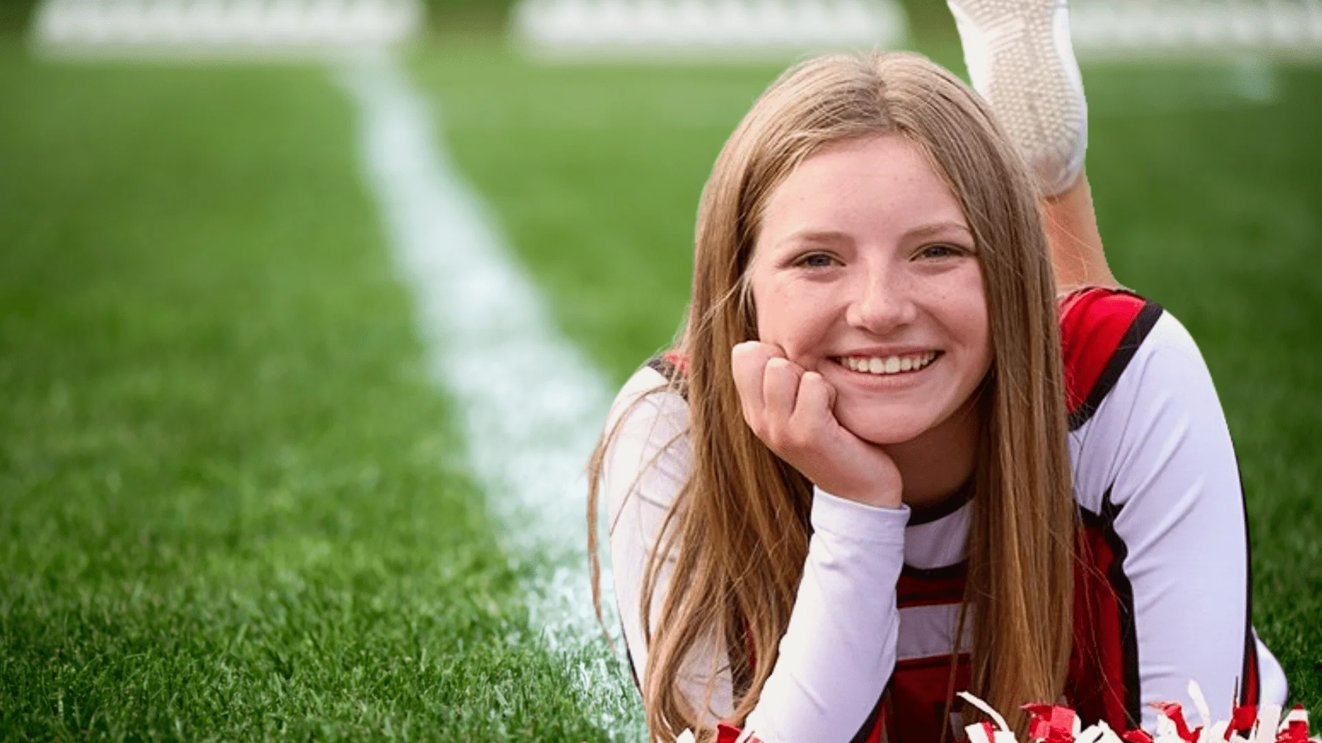 Teen cheerleader smiling on the field